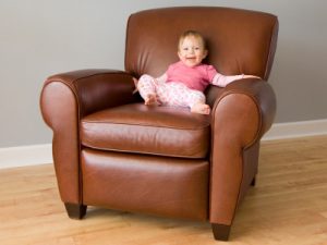 A toddler sitting on a leather chair
